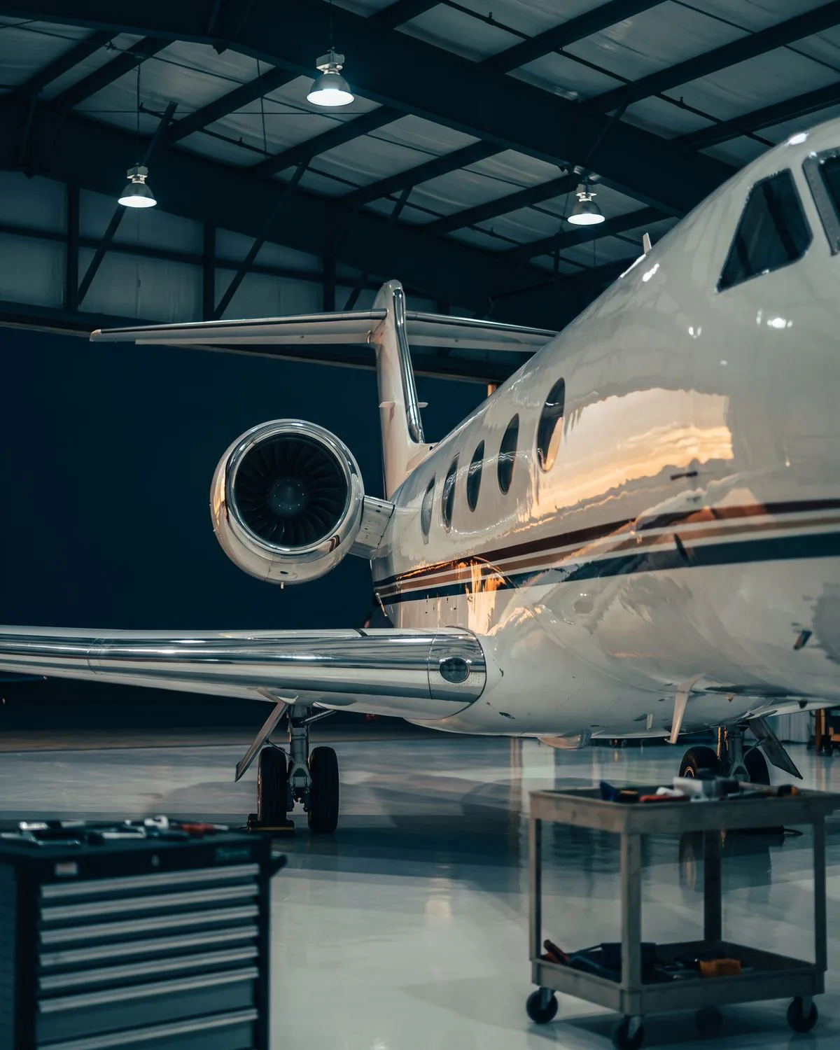 Business jet receiving maintenance attention inside a private hangar